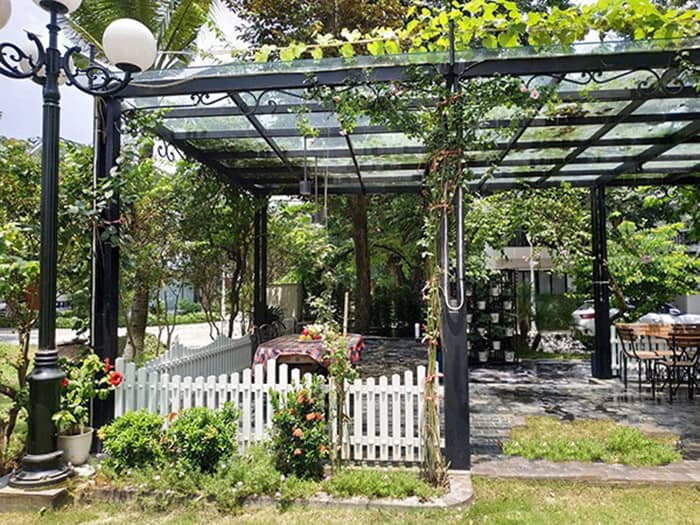 Mái kính sân vườn đẹp với nhiều cây lá bao quanh